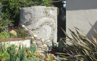Rainwater collection tank covered in mosaic by Alex Miller.